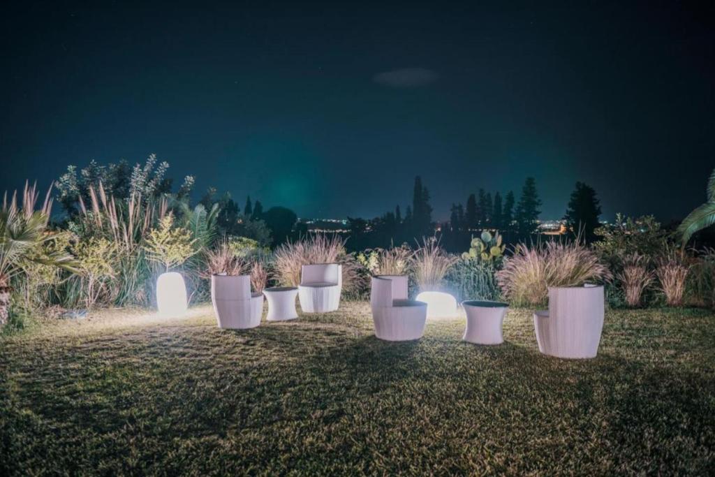 a row of white pots in a garden at night at villa palmi in Agrigento