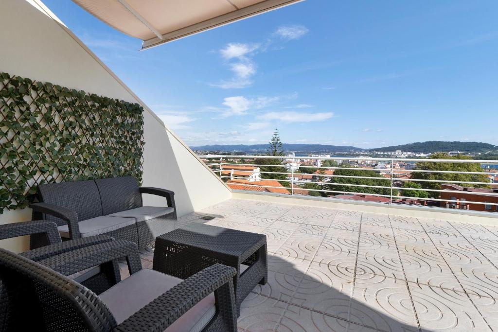 een balkon met stoelen en een tafel en uitzicht bij Villa Luzya in Viana do Castelo
