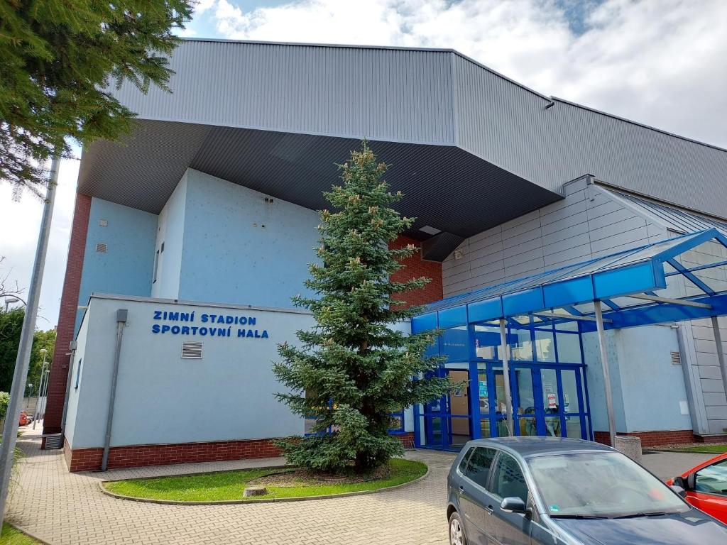a car parked in front of a building with a tree at Ubytovna Zimní stadion in Litoměřice