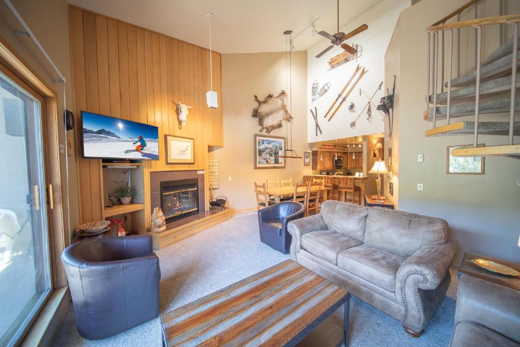 a living room with a couch and a tv at Ski Run 302 by SummitCove Lodging in Keystone