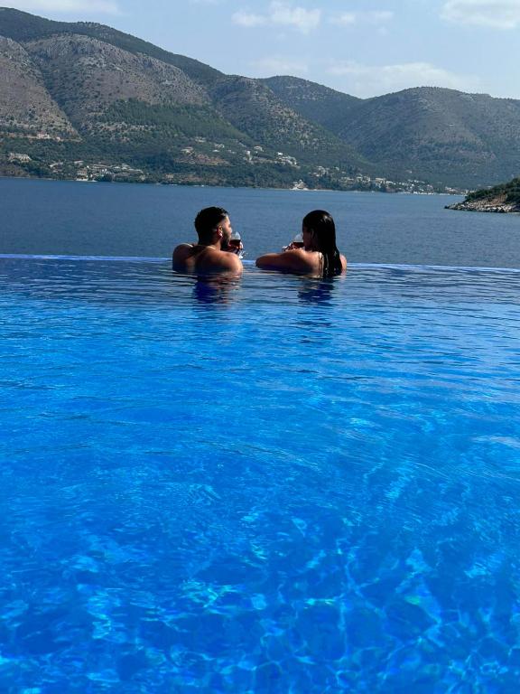 a man and a woman in a pool of water at Blue Bay Apartments in Syvota