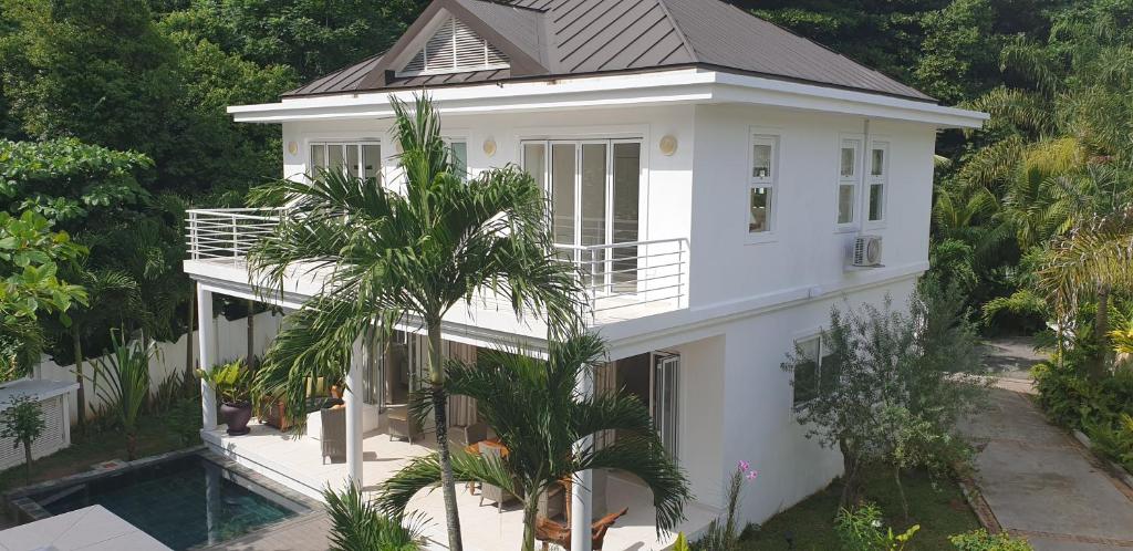 una casa blanca con piscina frente a ella en Las Brisas Villa - Chateau Elysium, en Beau Vallon