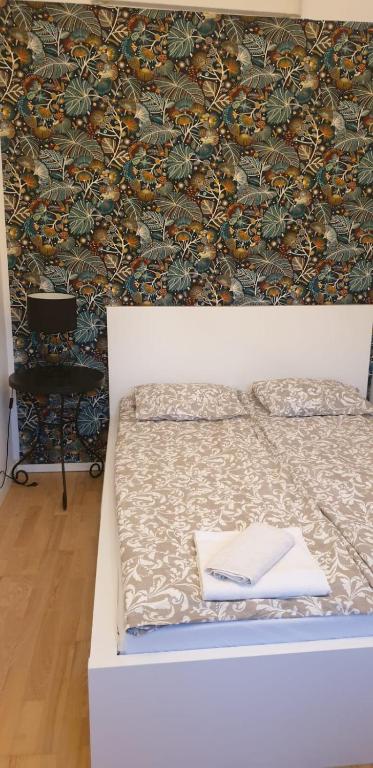 łóżko z książką obok ściany w obiekcie Apartament Turkusowy w Szczecinie