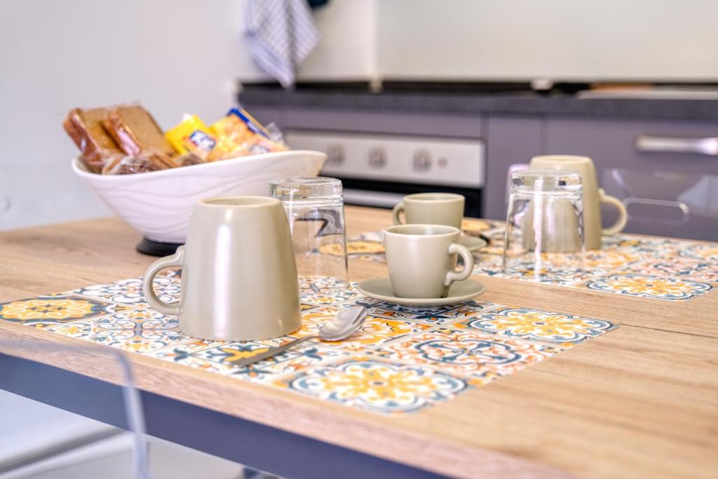 une table avec des tasses et des verres sur un comptoir de cuisine dans l'établissement Appartamento AL 45 B.go Roma -Vr- con garage, à Vérone