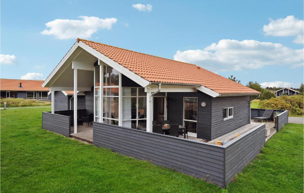 ein kleines Haus mit einer großen Terrasse im Hof in der Unterkunft Nice Home In Ulfborg With Wifi in Fjand Gårde