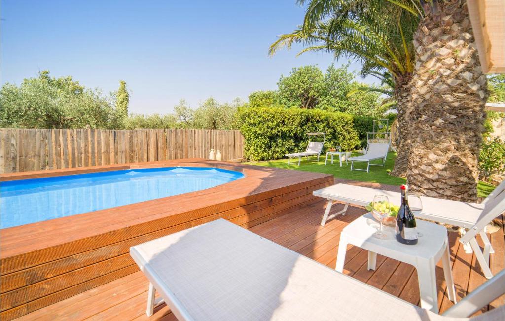 a backyard with a swimming pool and a wooden deck at Lovely Home In Partanna With Wifi in Partanna