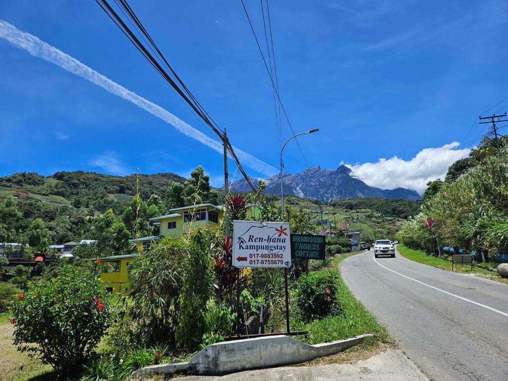 a sign on the side of a road with a mountain at Ren-Hana Kundasang in Kundasang