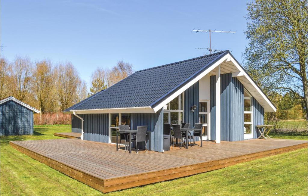 a house with a wooden deck in a yard at Nice Home In Strandby With Kitchen in Strandby