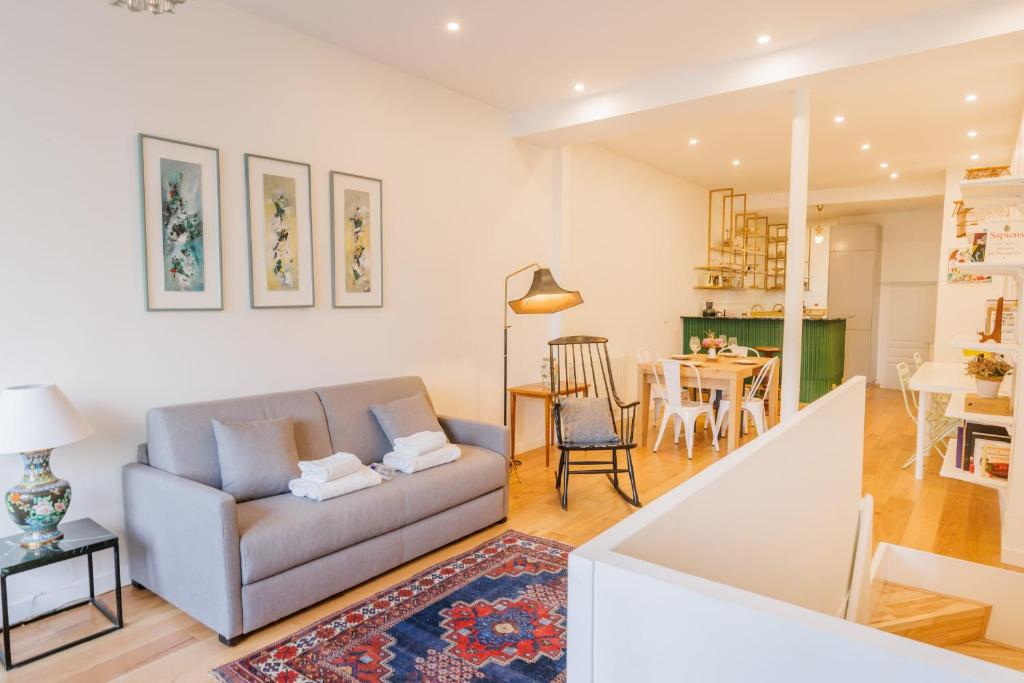a living room with a couch and a dining room at Cosy Loft between Montparnasse & Luxembourg Gardens in Paris