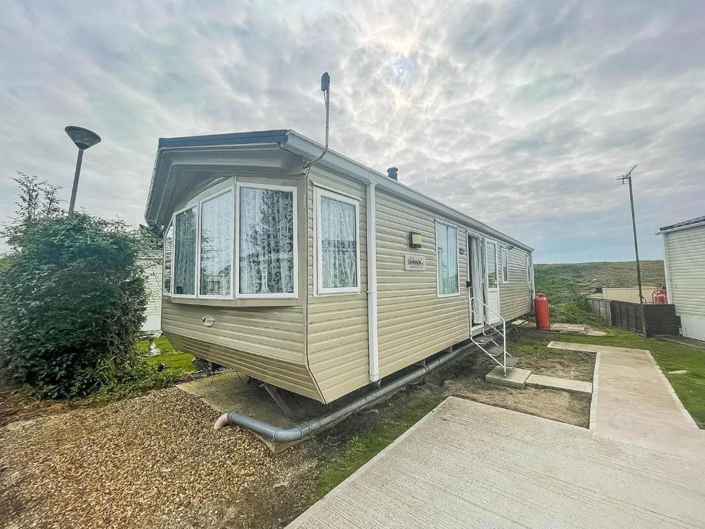 a mobile home is parked in a yard at Lovely 6 Berth Caravan With Wifi At Steeple Bay In Essex Ref 36028b in Southminster