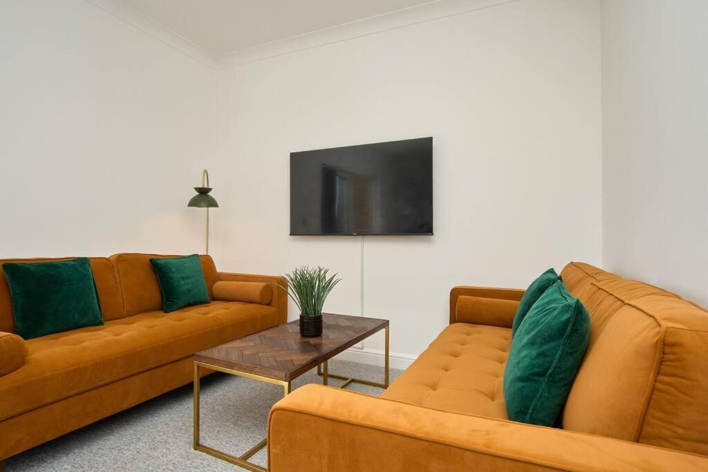 a living room with two couches and a tv at The Penthouse In Bonchurch Village by Greenstay Serviced Accommodation - Stunning 3 Bed Apt With Parking & Sea Views - The Perfect Choice For Families, Small Groups & Business Travellers in Ventnor