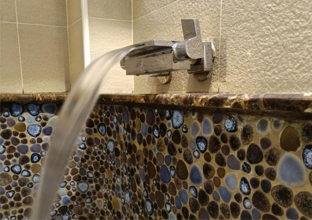 a shower with water coming out of a faucet at Kanalung Yurakucho House in Taimali