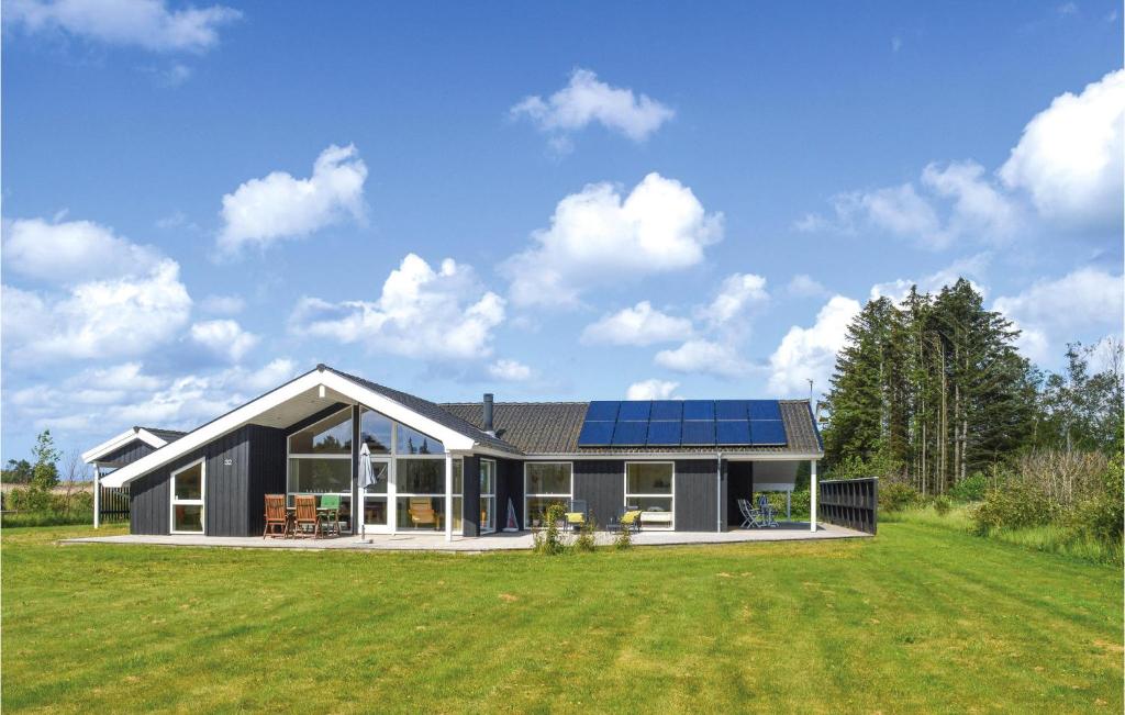 a house with solar panels on the side of a yard at Awesome Home In Jerup With 4 Bedrooms, Sauna And Wifi in Jerup