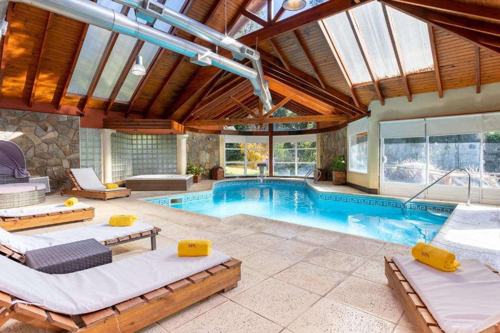 an indoor swimming pool with two beds and a pool house at Resort de montaña - La Comarca in Villa La Angostura