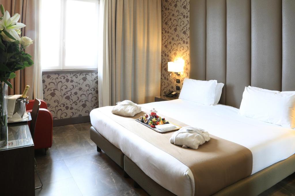 Una habitación de hotel con una cama con una bandeja de comida. en Klima Hotel Milano Fiere en Milán