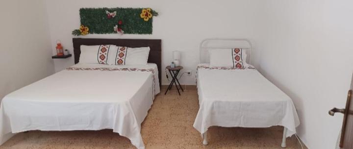 um quarto com 2 camas e lençóis brancos em Casa Familiar Boa Fé em Elvas