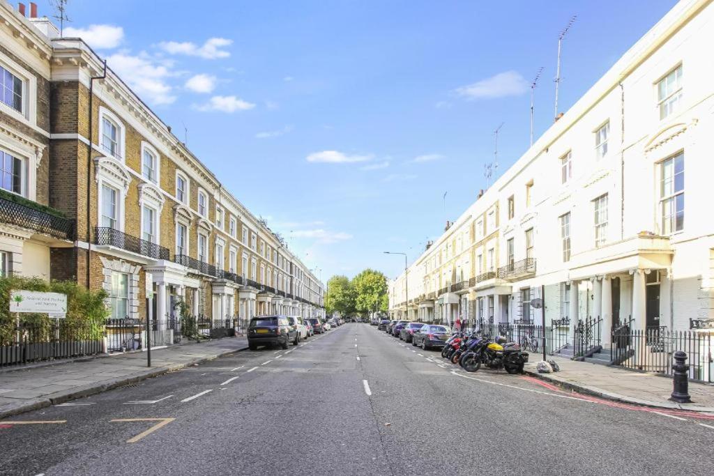 an empty street with cars parked on the side of a building at Fancy Basement Flat B in London