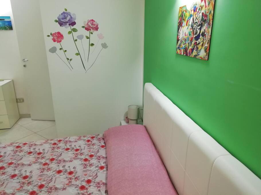 1 dormitorio con cama y pared verde en Colorful House Costa Trabocchi, en San Vito Chietino