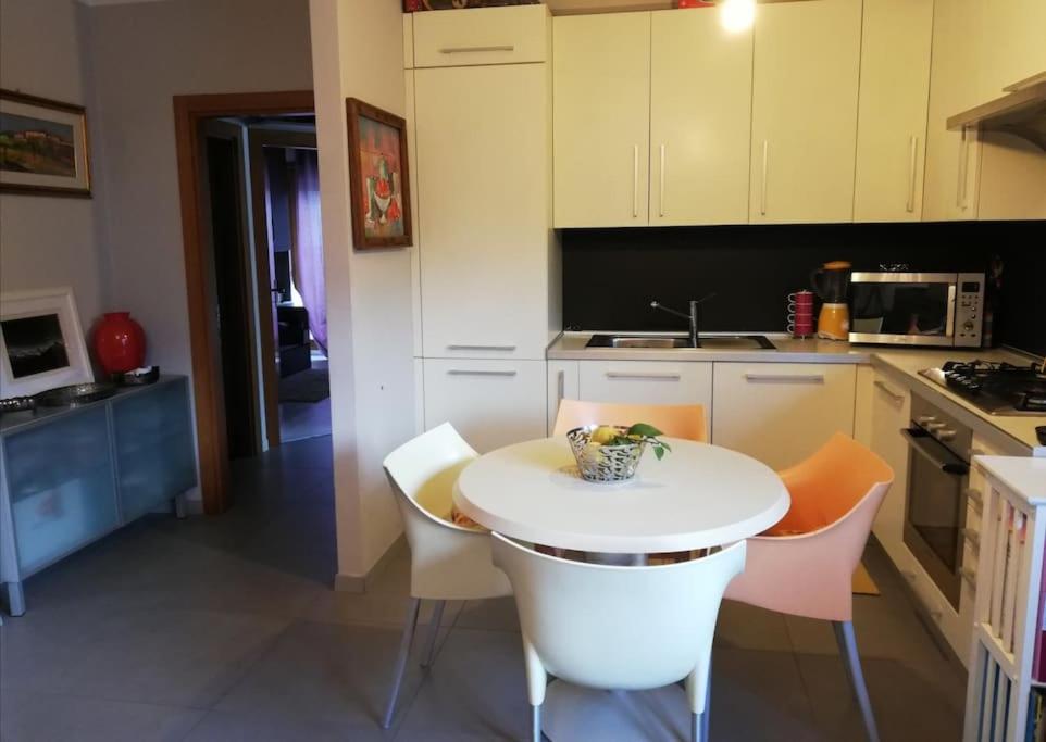 een keuken met een kleine witte tafel en stoelen bij CASA degli OLIVI GARDA LAKE in Riva del Garda