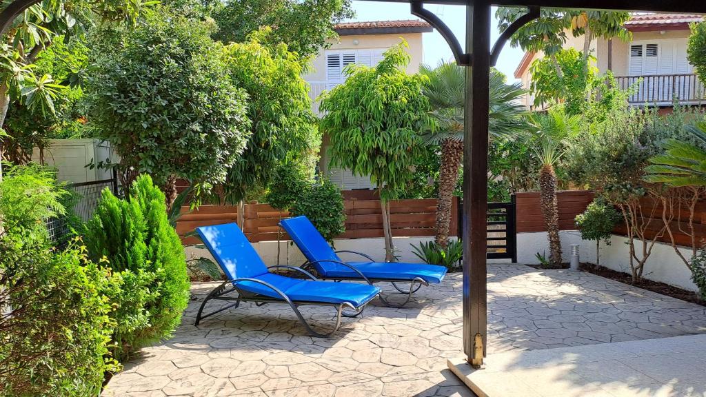 two blue chairs are sitting on a patio at Manors Seaside 2BR House 100m from the Beach & Free Parking in Meneou