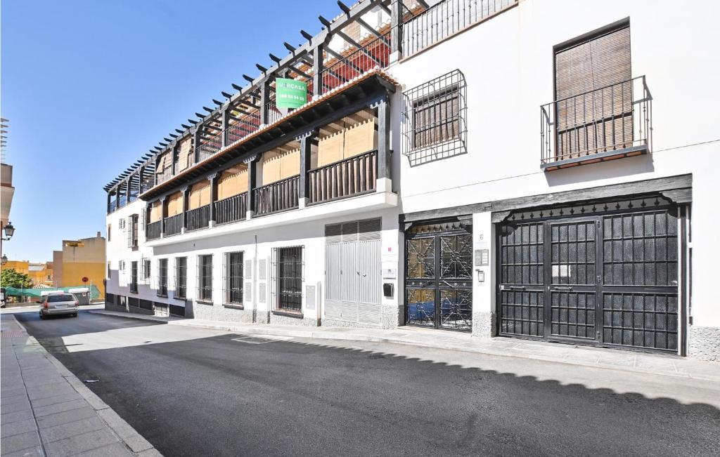 un edificio bianco con cancelli neri su una strada di 2 Bedroom Stunning Apartment In La Zubia a La Zubia