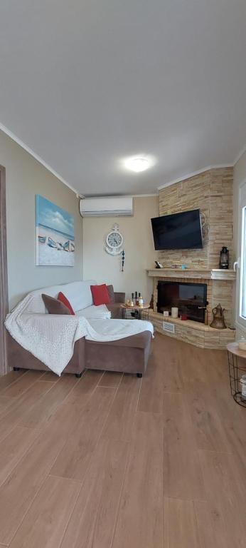 1 dormitorio con 1 cama grande y TV de pantalla plana en Guesthouse Eirini Porto Germeno, en Aigósthena