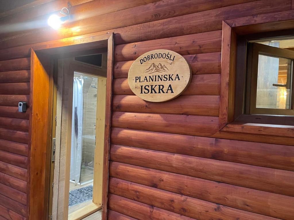 um sinal no lado de uma parede de madeira em Planinska iskra em Žabljak