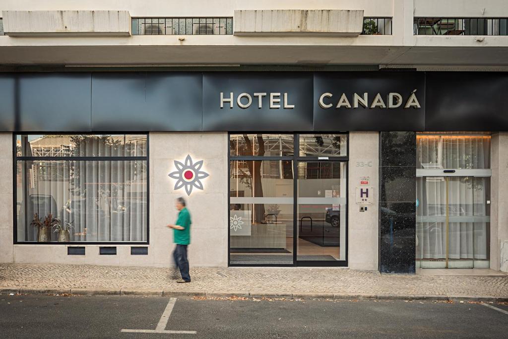 Ein Mann steht vor einem Hotel Canada. in der Unterkunft Hotel Canada in Lissabon