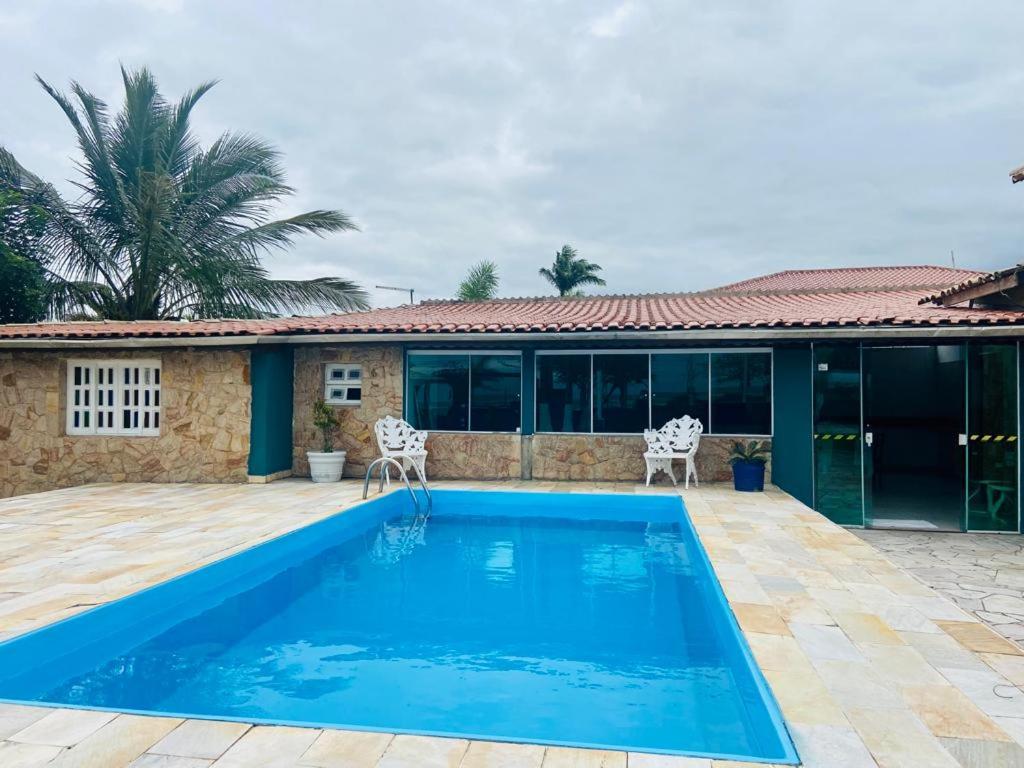 a swimming pool in front of a house at Pousada Riviera in Caraguatatuba