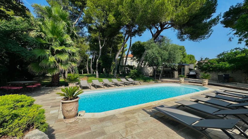 a swimming pool with chaise lounge chairs and a resort at Château Sainte Colombe in Saint-Geniès-des-Mourgues