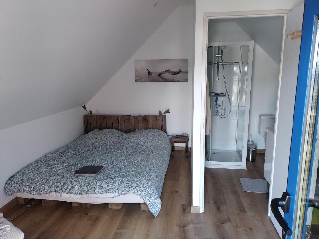 a bedroom with a bed and a walk in shower at A la campagne, au calme in Montérolier