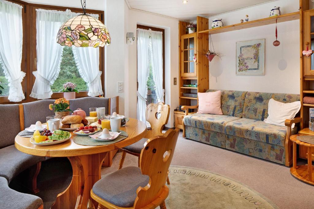 uma sala de estar com uma mesa e um sofá em Oskar em Titisee-Neustadt