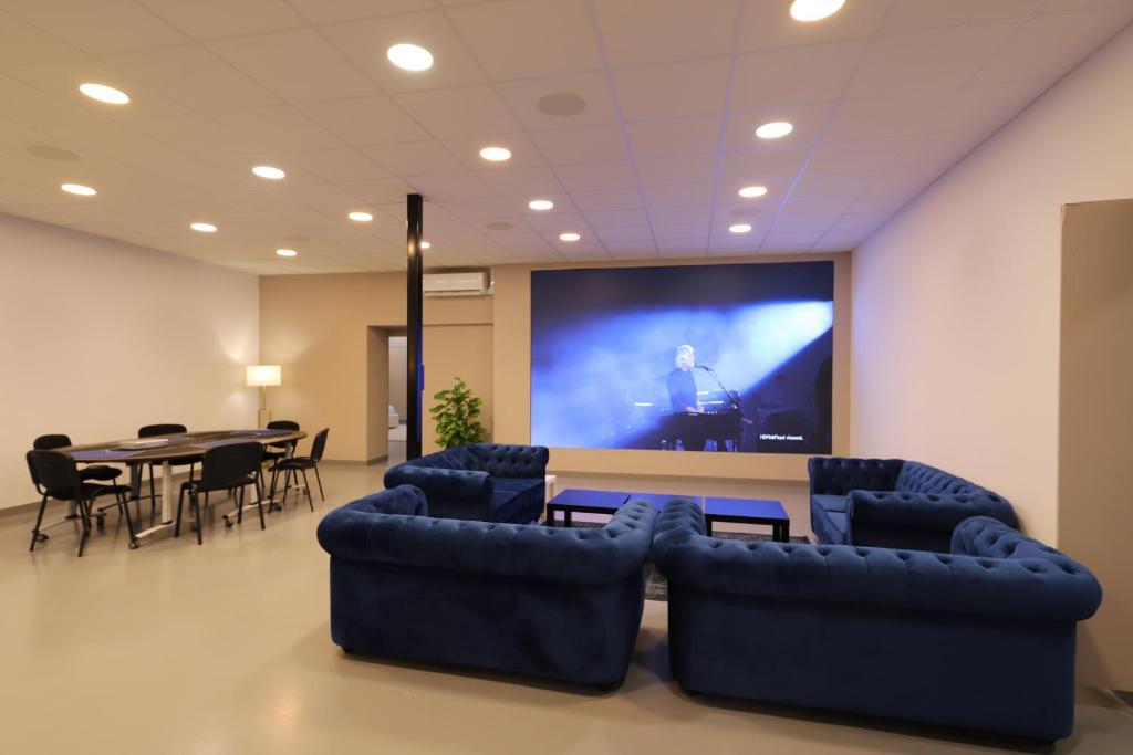 a room with a projection screen and a table and chairs at Loft 250m2 avec écran led géant de 10m2 in Marseille