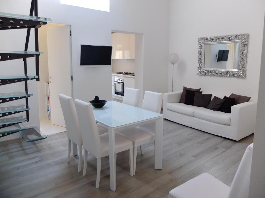 un soggiorno con tavolo bianco e sedie bianche di Casa Baroncelli a Siena