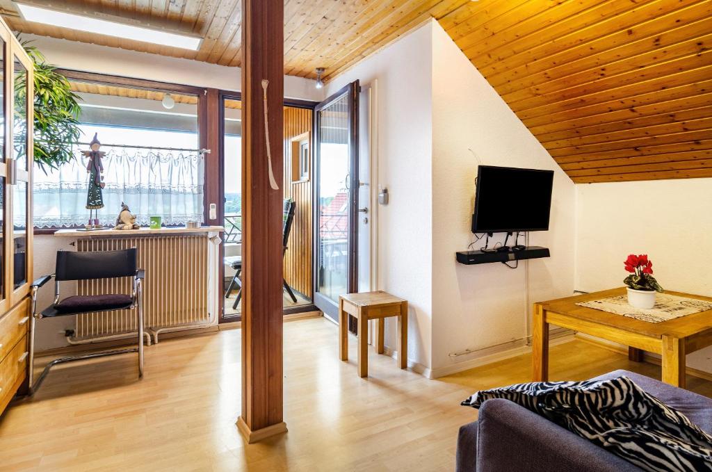 a living room with a couch and a television and a table at Dachwohnung Schneider Bingen in Mengen