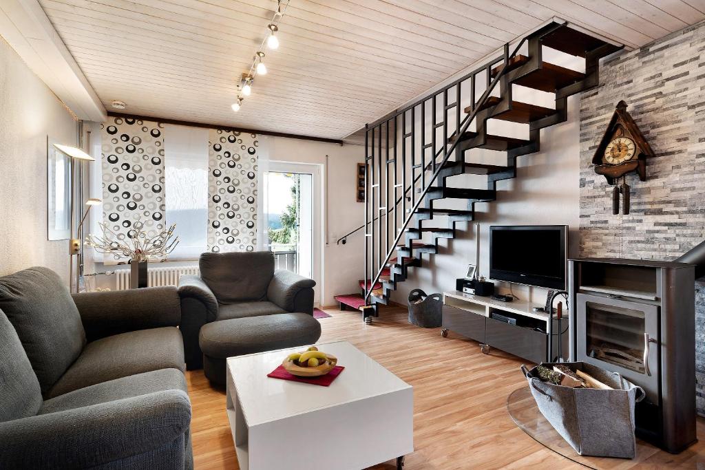 uma sala de estar com um sofá e uma escada em Klug em Obertal