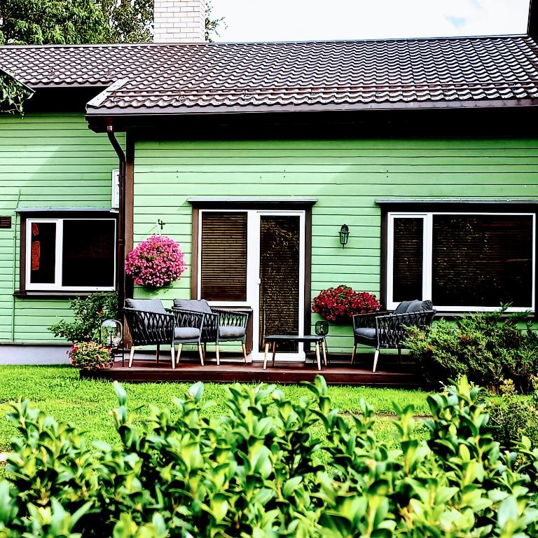 a green house with two chairs and a patio at Yasmin Apartment in Pärnu