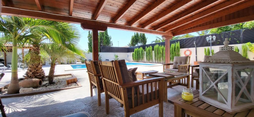 um pátio com uma mesa e cadeiras e uma palmeira em Villa Alicante Sunbeach em El Campello