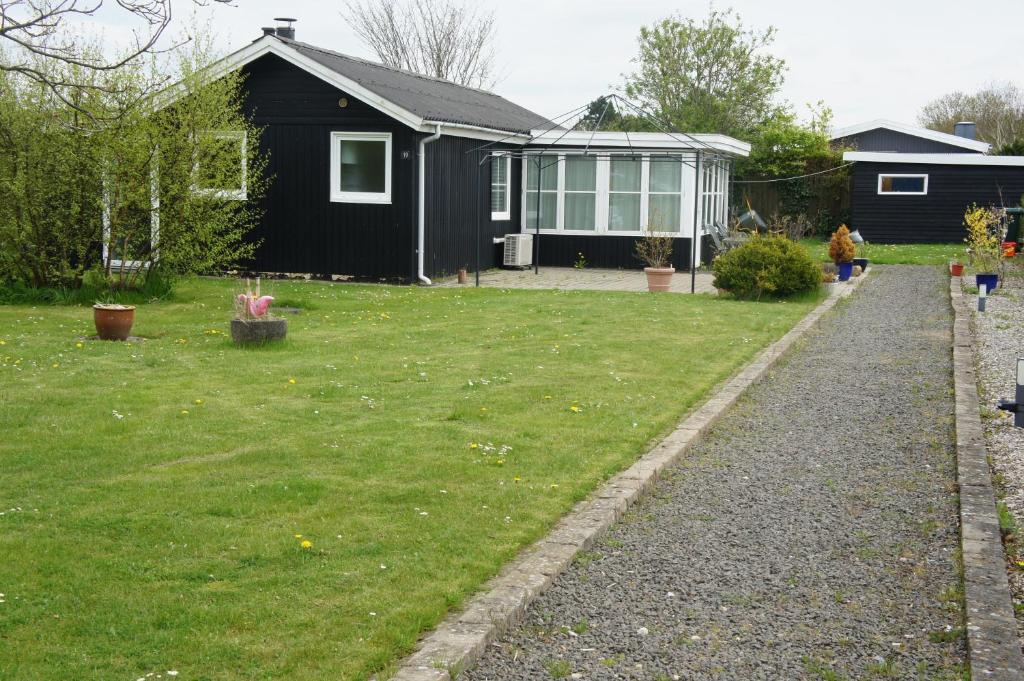 a backyard with a black house and a yard at (id 081) Åbakken 19 in Esbjerg