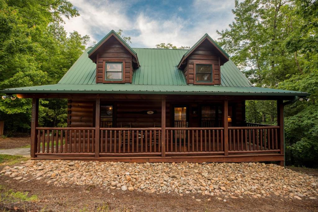 a log cabin with a green roof at Elegant & Cozy Cabin Near Pigeon Forge in Sevierville