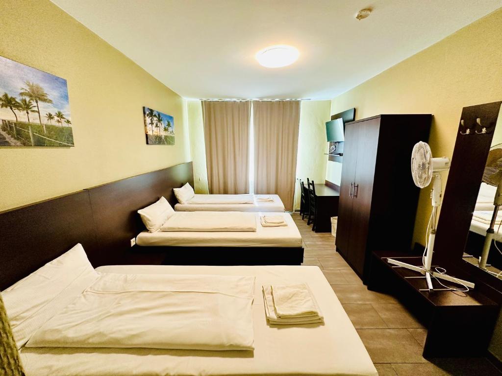 a hotel room with two beds and a tv at Hotel City Star in Frankfurt