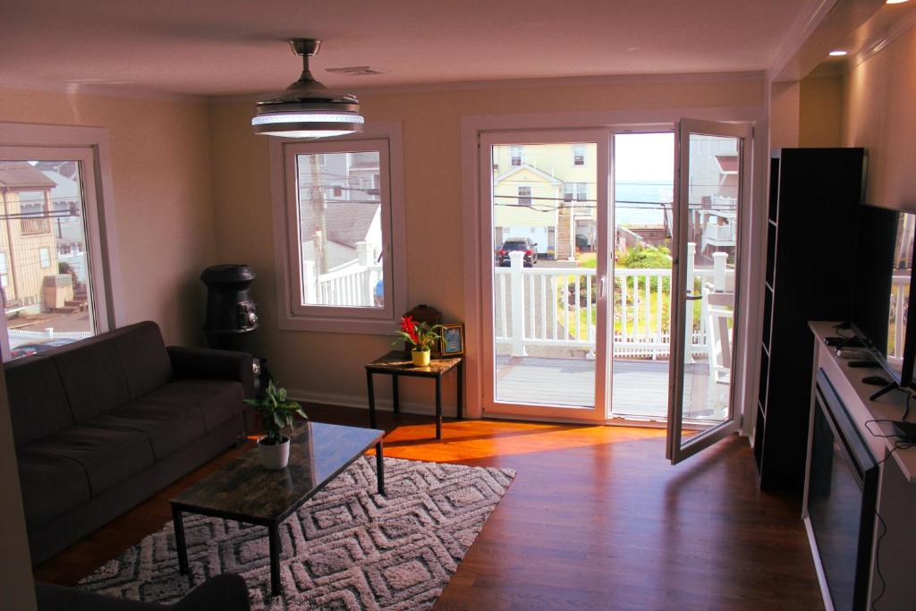 Cozy East Haven Apartment - Walk to Beach! في East Haven: غرفة معيشة بها أريكة وطاولة
