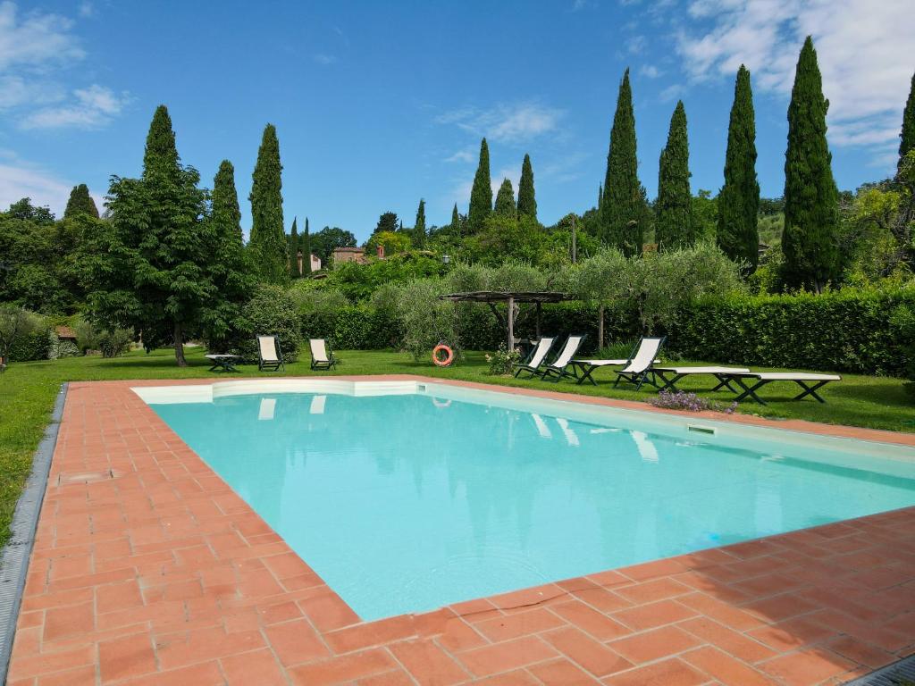 a swimming pool in a yard with chairs and trees at Agriturismo Mansi Bernardini in Lucca