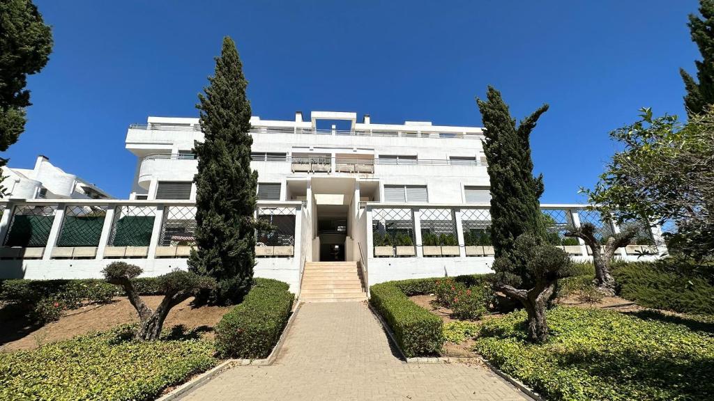 a white building with trees in front of it at Vitania Resort La Cala Apartment in Málaga