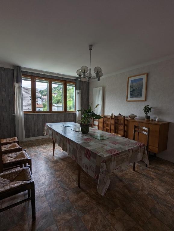 un salon avec une grande table et des chaises dans l'établissement Gite 'chez Cocotte', à La Bresse