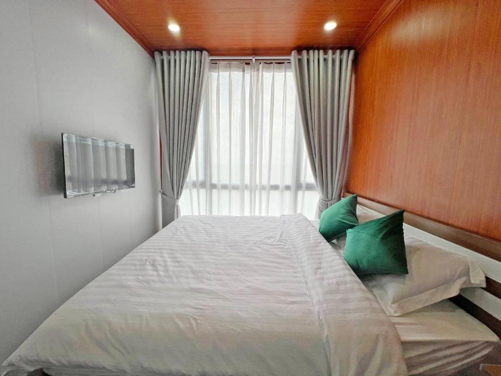 Xã Như LâmにあるHồ Cốc Park & Resortのベッドルーム1室(大型ベッド1台、緑の枕付)