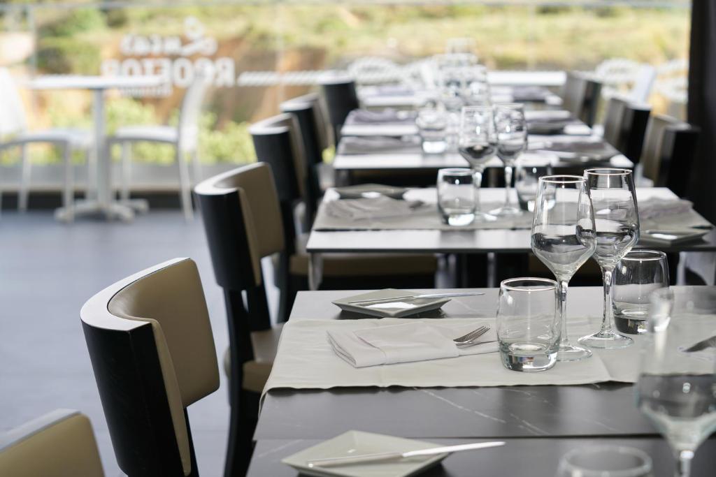 a row of tables with wine glasses and napkins at Carvi Beach Hotel in Lagos