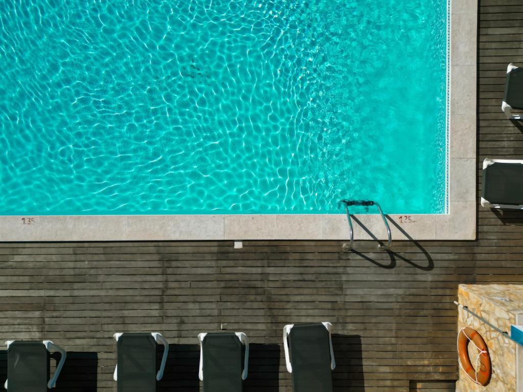 a swimming pool with chairs next to a large painting at Carvi Beach Hotel in Lagos