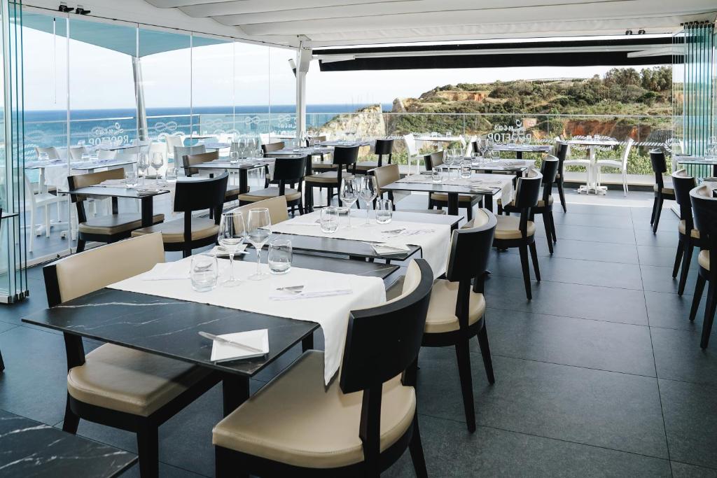 a restaurant with tables and chairs and a view of the ocean at Carvi Beach Hotel in Lagos