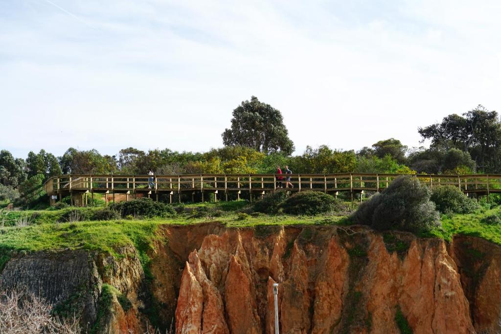 a bridge over a cliff with people walking on it at Carvi Beach Hotel in Lagos
